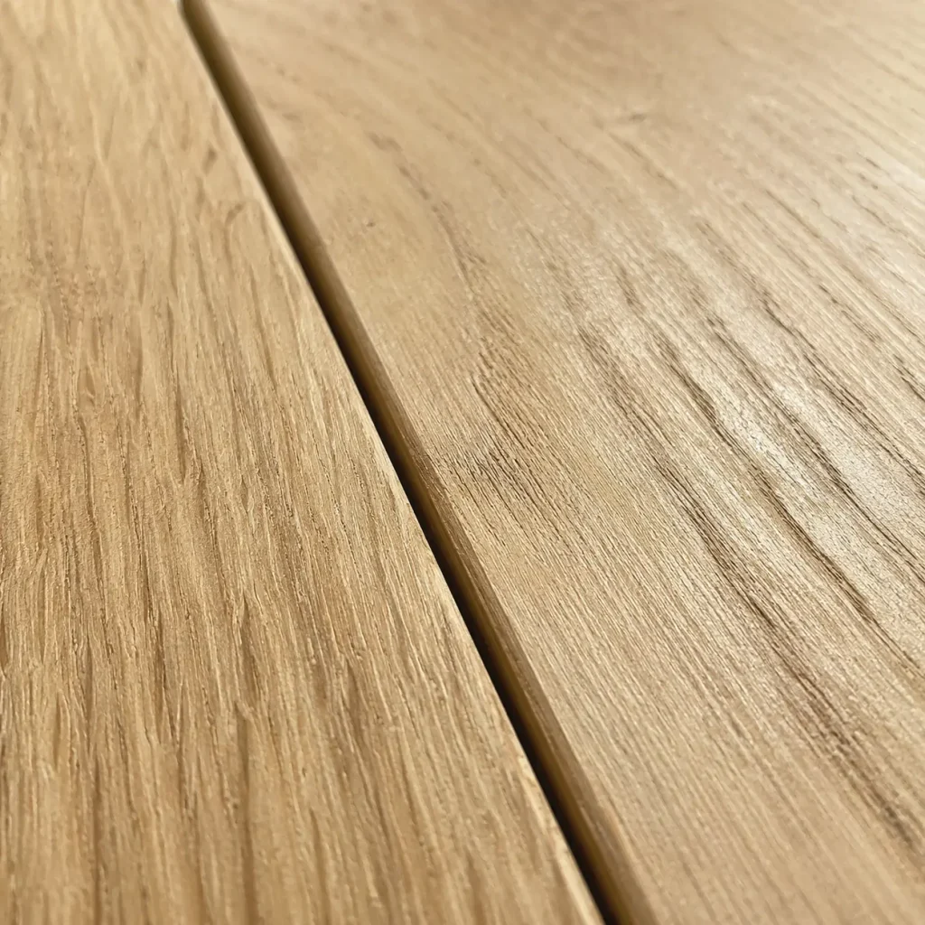 Close-up of a small gap between two timber floorboards showing wood shrinkage