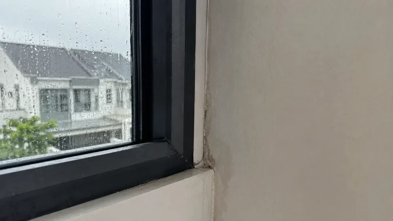 Rainwater appearing near a small gap beside an indoor window frame